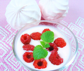   fresh raspberries with mint, yogurt and marshmallows. desserts on a patterned wicker surface        
