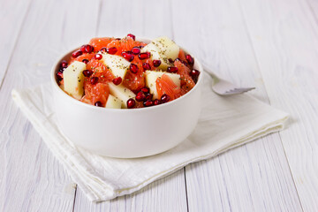 Fresh fruit salad in bowl on wooden table. Concept healthy food, diet, vegan