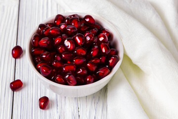 Pomegranate in white bowl on wooden table