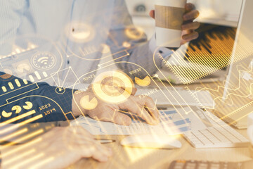 Technology theme hologram with man working on computer on background. High tech concept. Multi exposure.