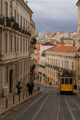Naklejka na ściany i meble Yellow tram circulating in a Lisbon street