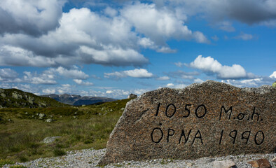 Sign indicating the height of the hill against the background of the mountains.