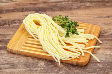Chechil spaghetti cheese over board