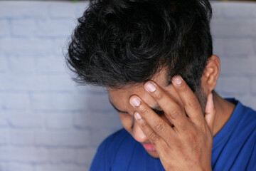 Fototapeta premium Close up of sad man covering face with hand.