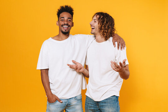 Cheerful multicultural two guys talking and hugging