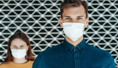 woman and a man in protective masks standing at a distance