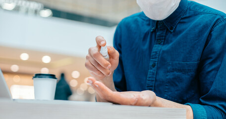close up. young man spraying antiseptic on his palm