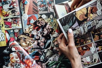 Naklejka premium hand flipping through comic book pages. Comics background. Rostov-on-Don, Russia. 1 August 2019