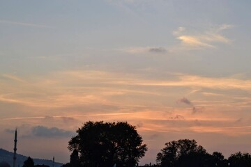 Sky of Bursa, Turkey during the sunset. Silhouette of minaret of a local mosque and plane tree and Ulu Mountain.