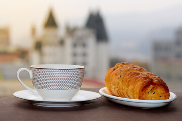 Coffee cup and breakfast cake with luxury hotel background