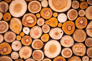 Christmas texture background of dry wooden log cabins. Woodpile of cut Lumber for forestry industry