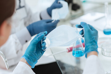 close up. female scientist putting on a protective mask .