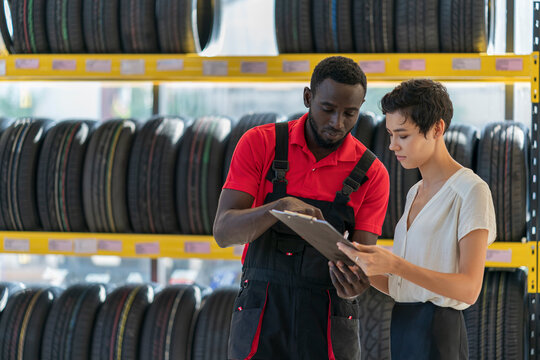 A technician provide service and talking to a customer in the auto service canter/tires service center