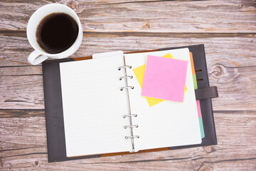 post it note and diary with coffee on wooden background