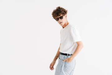 Fototapeta premium Young curly caucasian guy in sunglasses looking at camera