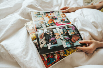 Naklejka premium Woman reading comic book in the bed at home. Rostov-on-Don, Russia. 14 April 2020
