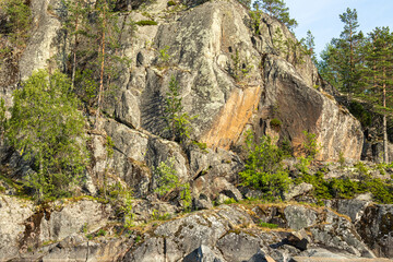 beautiful landscape with green, natural plants, trees on a mountain, rocks on an island near a reservoir, lake in the summer of Karelia, Russia