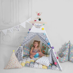 child playing with toys in a teepee © Alexander