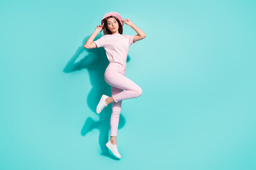 Fototapeta na wymiar Full length body size view of her she nice attractive pretty lovely cheerful girl jumping having fun pout lips touching hat isolated bright vivid shine vibrant green turquoise color background