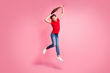 Full size photo of crazy kid girl jump make ponytail haircut wear red casual style clothes isolated over pastel color background