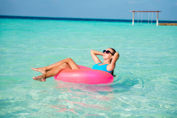 Portrait of her she nice attractive gorgeous fit slim healthy tanned girl lying on rubber circle floating enjoying sunny hot day weather luxury resort spa clear clean transparent aqua