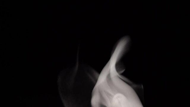 Stretching white smoke on a black background. Abstract white smoke in slow motion. Floating fog.