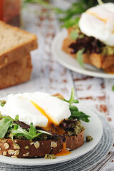 Homemade sandwiches with pesto, green salad and poached eggs