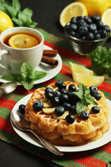 Belgian waffles with blueberry and a cup of tea with lemon