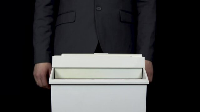 Shredder destroys one hundred euro bill. A man thrusts money into a paper shredder