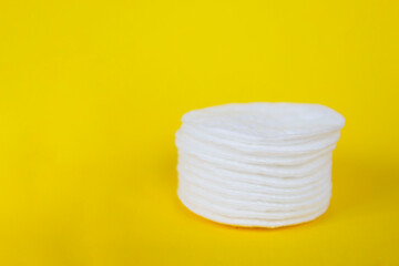 cotton pads for skin care on yellow background, flat place for text