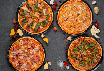 Four types of pizza shot from above on wooden boards