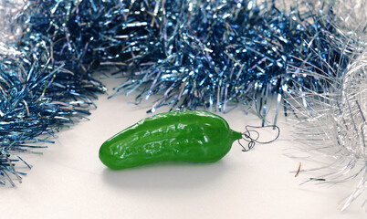 Vintage Christmas toy (cucumber) among glittering tinsel