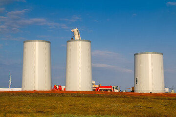 Windmill construction. Installation of wind turbine. Blue sky.