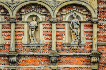Obraz premium Impressive bricked wall and gorgeous decoration with sculptures at Frederiksborg Castle (Frederiksborg Slot, XVII century) - old royal residence for King Christian IV. Hillerod, Denmark.