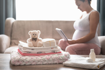 Pregnant woman is getting ready for the maternity hospital, packing baby stuff.