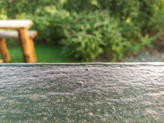 Texture of black-grey stone with blurred garden background