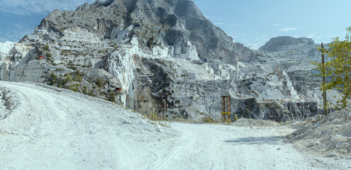Fototapeta na wymiar mountain white road climbing at white marble quarry, Carrara, Italy