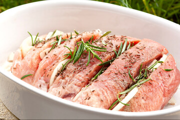 Raw pork meat with fresh herbs and spices.