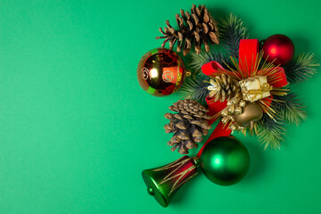 Christmas decorations on a green background. Red and green Christmas balls. Christmas tree toys. Celebratory decorations.