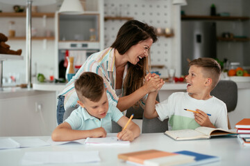 Mother helping her son with homework at home. Little boy learning at home..