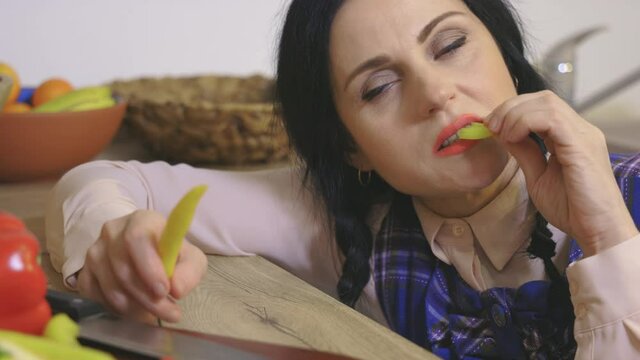 Woman try to eat sweet pepper or chili pepper