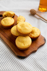 Naklejka premium Homemade Cornbread Muffins on a rustic wooden board, side view.