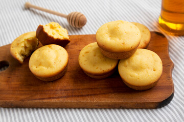 Homemade Cornbread Muffins on a rustic wooden board, side view. Close-up.