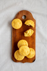 Homemade Cornbread Muffins on a rustic wooden board, overhead view. Flat lay, from above, top view.