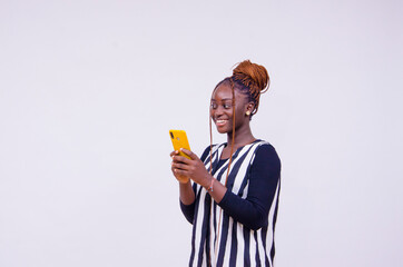 Fototapeta premium young black lady holding a smart phone and smiling.
