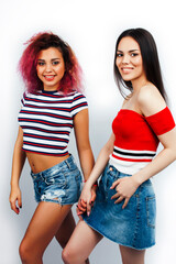 best friends diverse races teenage girls together having fun, asian and african , posing emotional on white background, lifestyle people concept