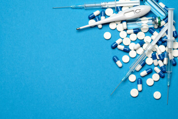 Fototapeta na wymiar Top view of Pills, Syringe, Thermometer And Ampoule With Vaccination On blue background with copy space