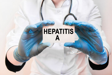 The doctor's blue - gloved hands show the word HEPATITIS A - . a gloved hand on a white background. Medical concept. the medicine