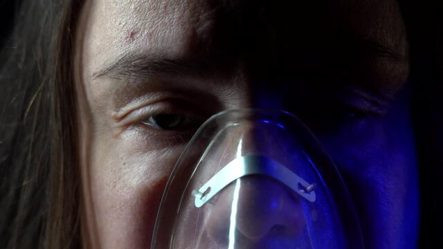 Close-up of a middle-aged woman with a cold doing inhalations with a mask on her face. Concept a sick patient treats himself with an inhaler.