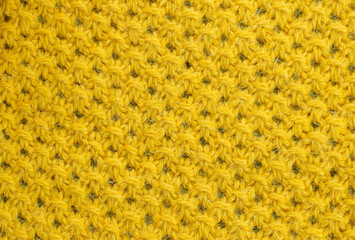 Texture of knitted woolen fabric of yellow color for Wallpaper and an abstract background.